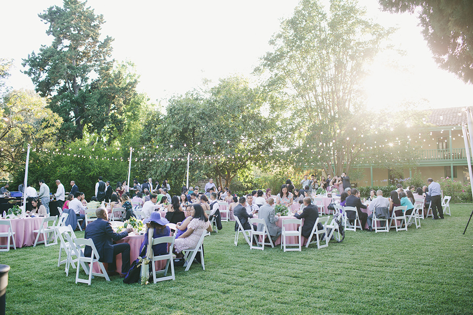  garden wedding at rancho los Cerritos with the groom in a rose pink suit and the groomsmen in navy suits 