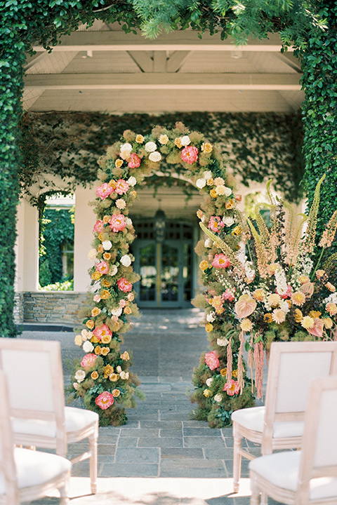  old world garden wedding design with yellow and pink flowers and the groom in a navy shawl tuxedo – ceremony arch 