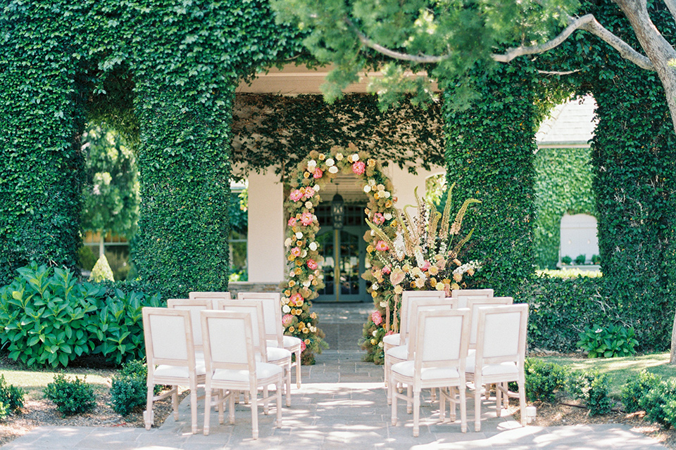  old world garden wedding design with yellow and pink flowers and the groom in a navy shawl tuxedo