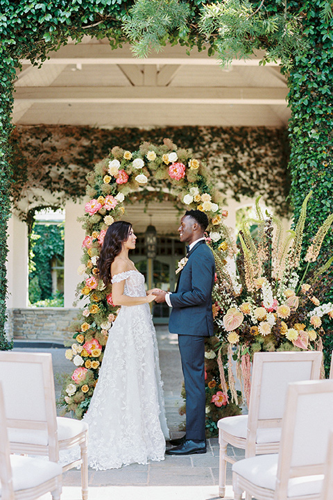  old world garden wedding design with yellow and pink flowers and the groom in a navy shawl tuxedo – ceremony 