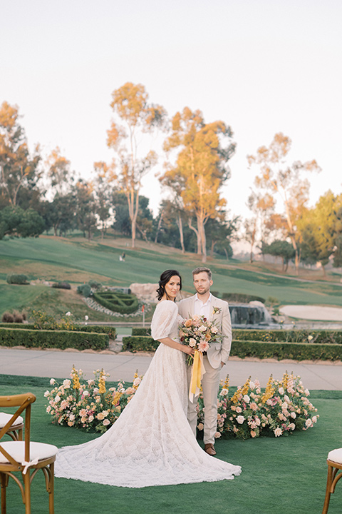  a neutral romantic wedding with touches of peach colors and the groom in a tan suit- bride 