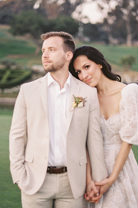  a neutral romantic wedding with touches of peach colors and the groom in a tan suit- at the venue 