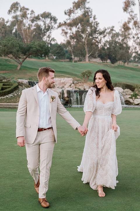  a neutral romantic wedding with touches of peach colors and the groom in a tan suit- at the venue 