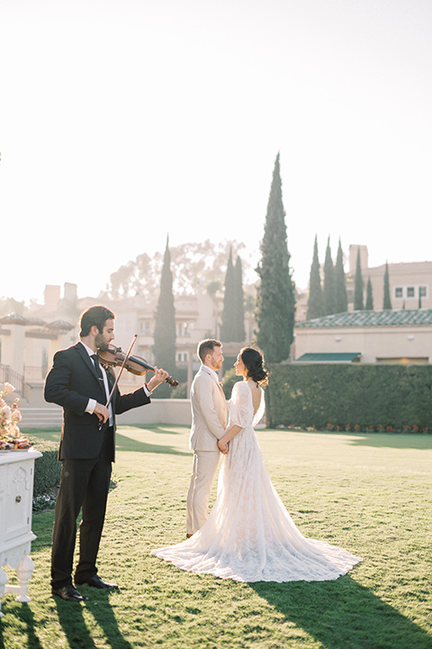  a neutral romantic wedding with touches of peach colors and the groom in a tan suit- bride 