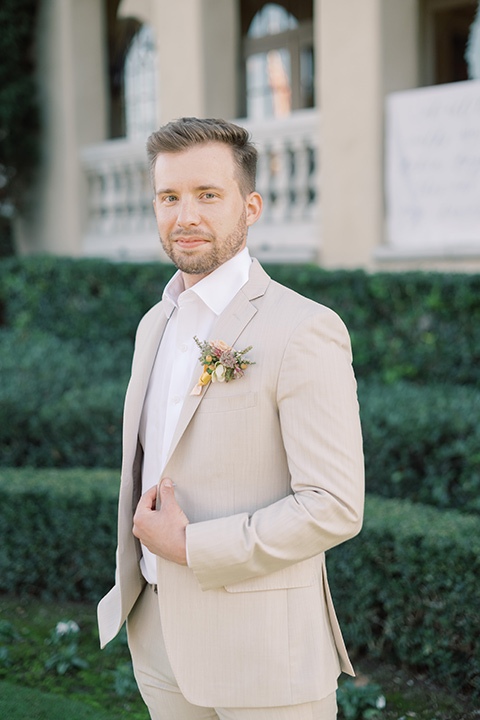  a neutral romantic wedding with touches of peach colors and the groom in a tan suit- groom 