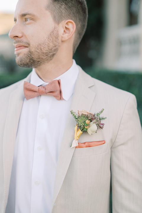  a neutral romantic wedding with touches of peach colors and the groom in a tan suit- bride 