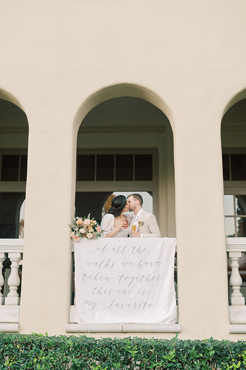  a neutral romantic wedding with touches of peach colors and the groom in a tan suit- bride 