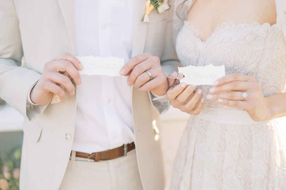  a neutral romantic wedding with touches of peach colors and the groom in a tan suit 