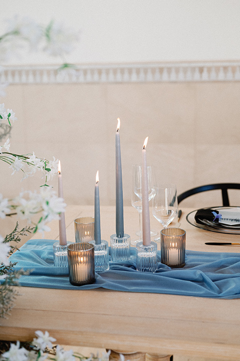 a wedding at the grand gimeno with white, blue, and gold accents – the bride wore a long sleeved modern fitted gown and the groom wore a light blue suit with velvet bow tie – reception table décor 