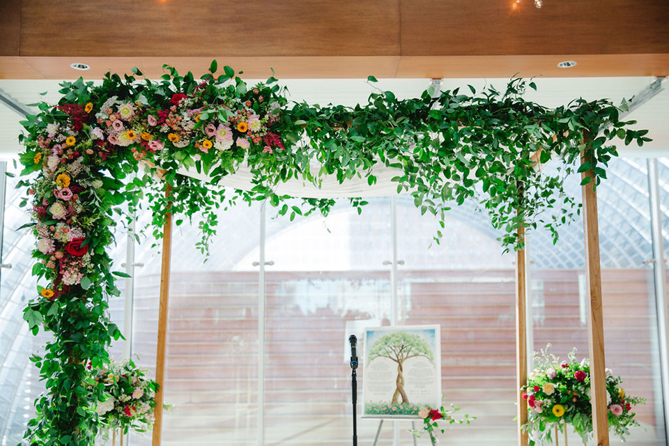  a downtown wedding at the cultural center with the groom and groomsmen in green suits and the bridesmaids in blush dresses and the bride in an a-line gown- ceremony wedding alter with greenery and pink florals