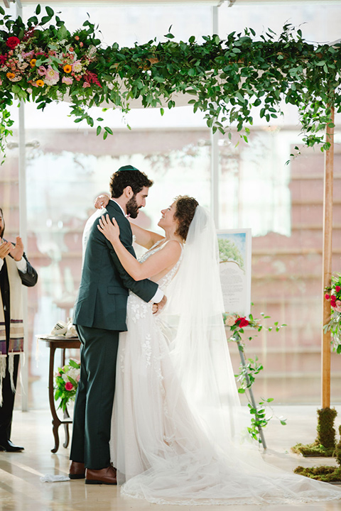  a downtown wedding at the cultural center with the groom and groomsmen in green suits and the bridesmaids in blush dresses and the bride in an a-line gown- first kiss 