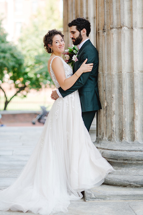 a downtown wedding at the cultural center with the groom and groomsmen in green suits and the bridesmaids in blush dresses and the bride in an a-line gown- couple laughing outside 