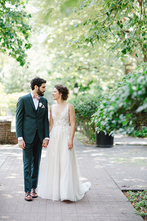  a downtown wedding at the cultural center with the groom and groomsmen in green suits and the bridesmaids in blush dresses and the bride in an a-line gown- couple laughing outside 