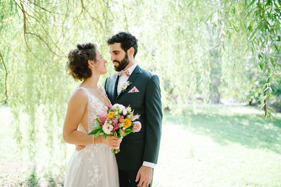  a downtown wedding at the cultural center with the groom and groomsmen in green suits and the bridesmaids in blush dresses and the bride in an a-line gown- couple looking at each other in the garden