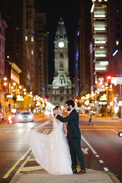  a downtown wedding at the cultural center with the groom and groomsmen in green suits and the bridesmaids in blush dresses and the bride in an a-line gown- couple walking in the street at night 