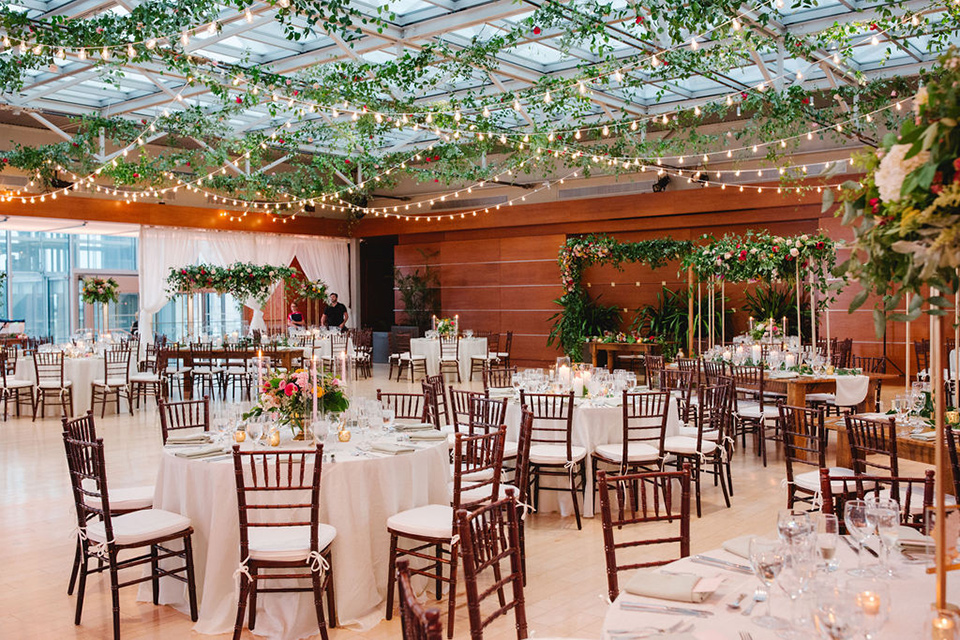  a downtown wedding at the cultural center with the groom and groomsmen in green suits and the bridesmaids in blush dresses and the bride in an a-line gown- reception tables with gorgeous lighting and greenery