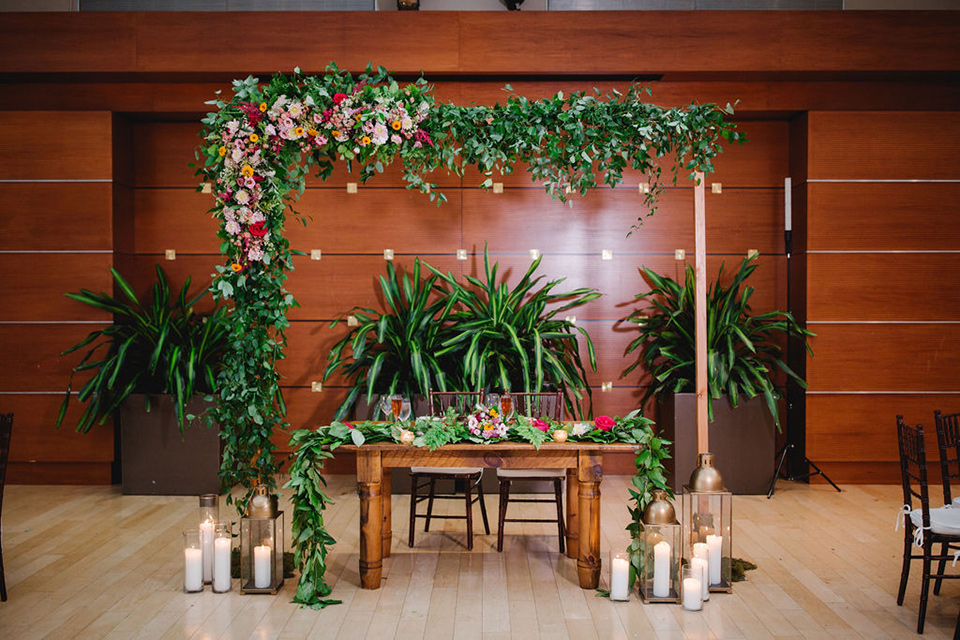 a downtown wedding at the cultural center with the groom and groomsmen in green suits and the bridesmaids in blush dresses and the bride in an a-line gown- sweetheart table with a wood table and ivy