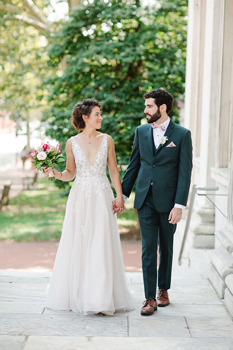  a downtown wedding at the cultural center with the groom and groomsmen in green suits and the bridesmaids in blush dresses and the bride in an a-line gown- couple walking outside the venue