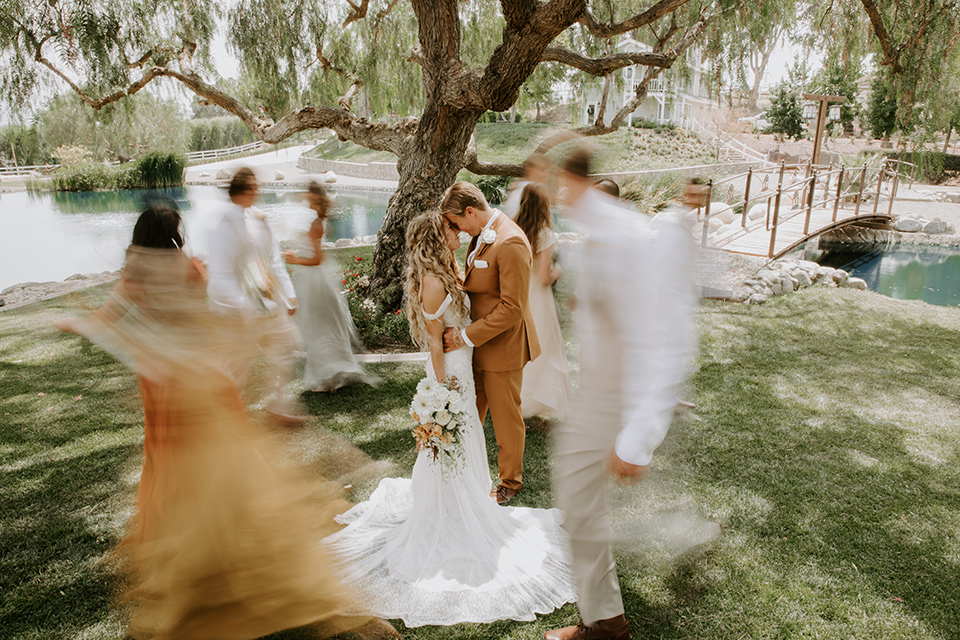  rustic boho wedding with warm colors and the bride in an off the shoulder gown and the groom in a caramel suit 