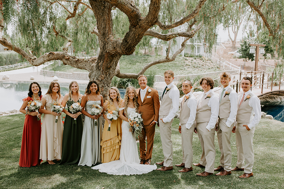 rustic boho wedding with warm colors and the bride in an off the shoulder gown and the groom in a caramel suit 