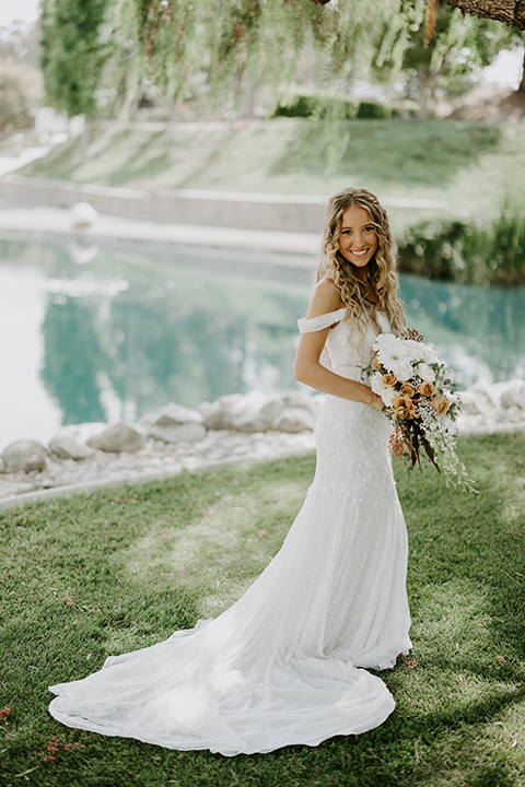  rustic boho wedding with warm colors and the bride in an off the shoulder gown and the groom in a caramel suit 