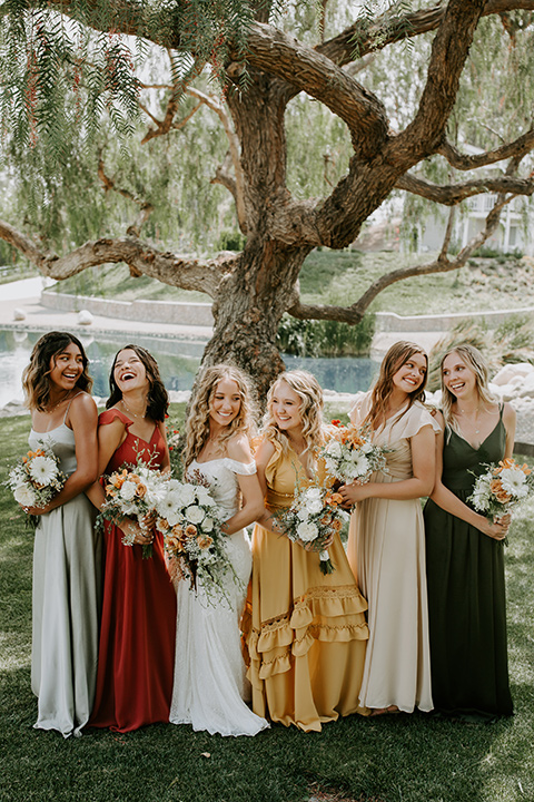  rustic boho wedding with warm colors and the bride in an off the shoulder gown and the groom in a caramel suit 