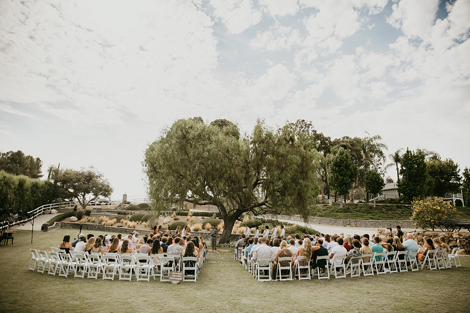  rustic boho wedding with warm colors and the bride in an off the shoulder gown and the groom in a caramel suit 