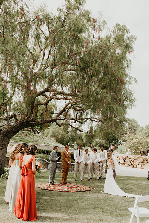  rustic boho wedding with warm colors and the bride in an off the shoulder gown and the groom in a caramel suit 