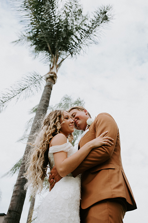  rustic boho wedding with warm colors and the bride in an off the shoulder gown and the groom in a caramel suit 