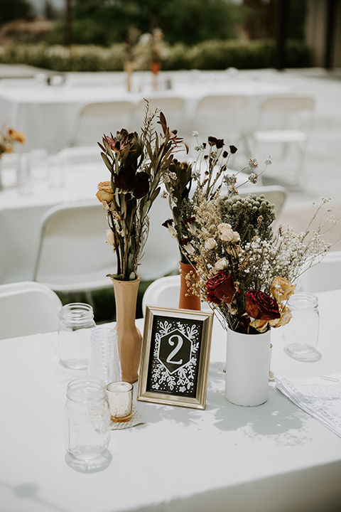  rustic boho wedding with warm colors and the bride in an off the shoulder gown and the groom in a caramel suit 