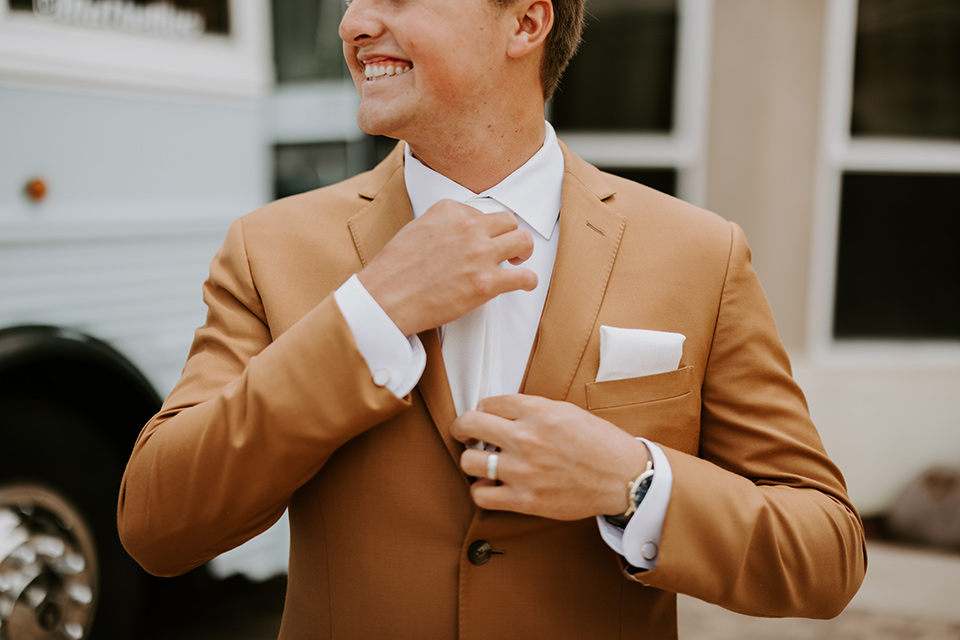  rustic boho wedding with warm colors and the bride in an off the shoulder gown and the groom in a caramel suit 