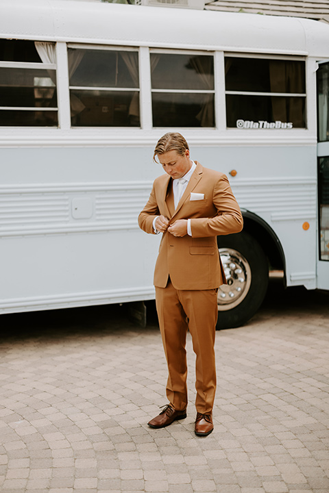  rustic boho wedding with warm colors and the bride in an off the shoulder gown and the groom in a caramel suit 