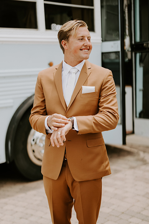  rustic boho wedding with warm colors and the bride in an off the shoulder gown and the groom in a caramel suit 