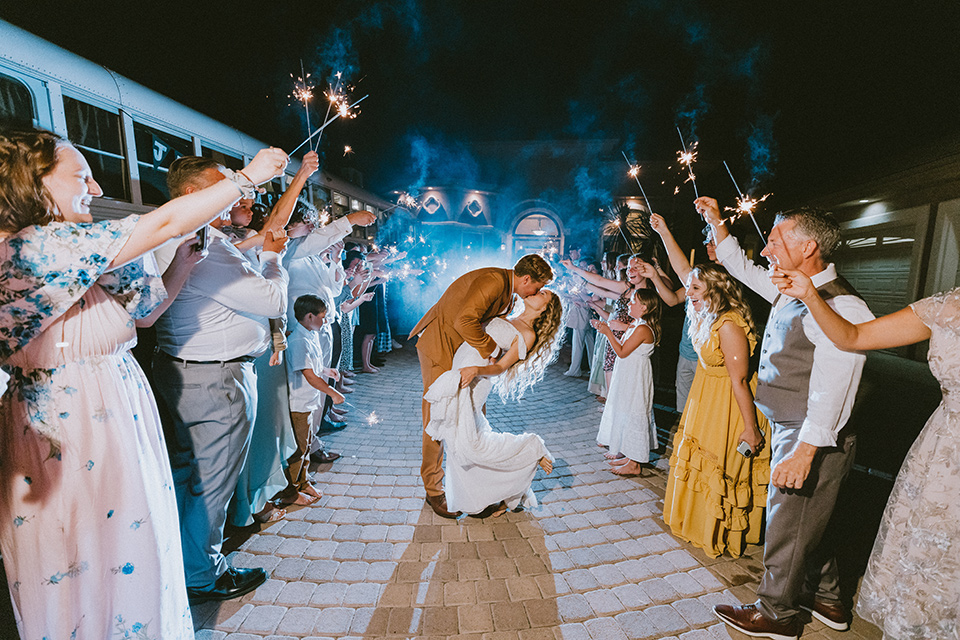  rustic boho wedding with warm colors and the bride in an off the shoulder gown and the groom in a caramel suit 