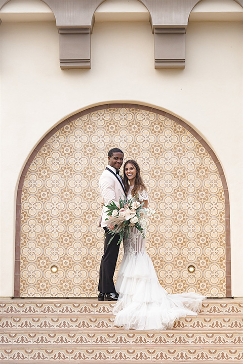  glamorous wedding at Terranea Resort in Paso Robles with the bride in a fitted lace gown with long sleeves and the groom in a blush pink tuxedo 