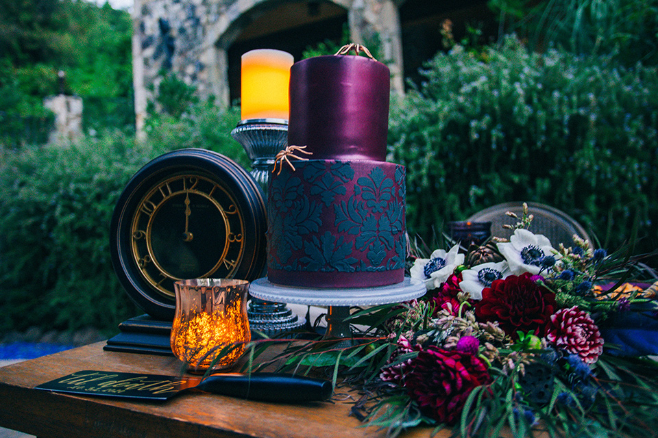  the nightmare before Christmas styled wedding with the bride in a black gown and the groom in a burgundy tuxedo 