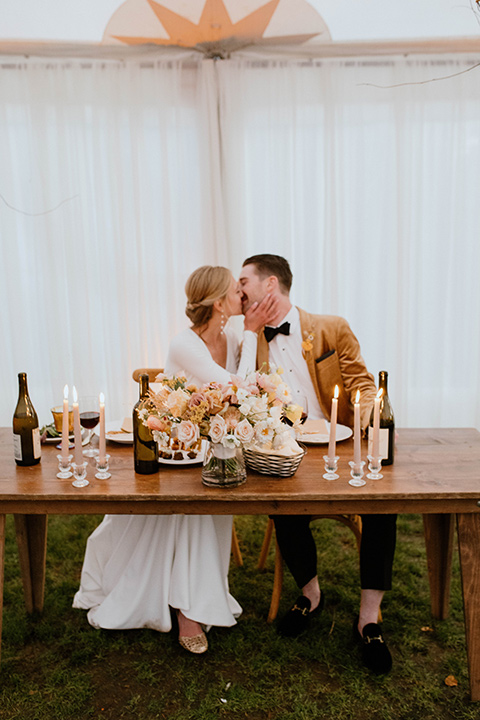  lizzie and tommys wedding on the beach with neutral colors and a gold velvet jacket – couple sitting