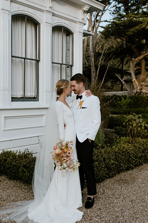  lizzie and tommys wedding on the beach with neutral colors and a gold velvet jacket – couple sitting