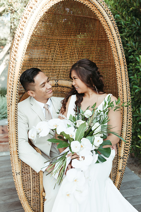  fun and tropical wedding inspired by Bali – bride and groom sitting in a chair  