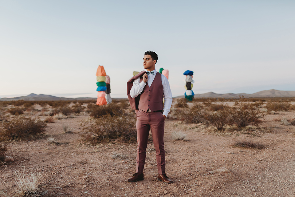  how to rent a suit or tuxedo in las vegas young man standing in the middle of the nevada desert wearing a stylish tuxedo with the coat thrown over one shoulder 