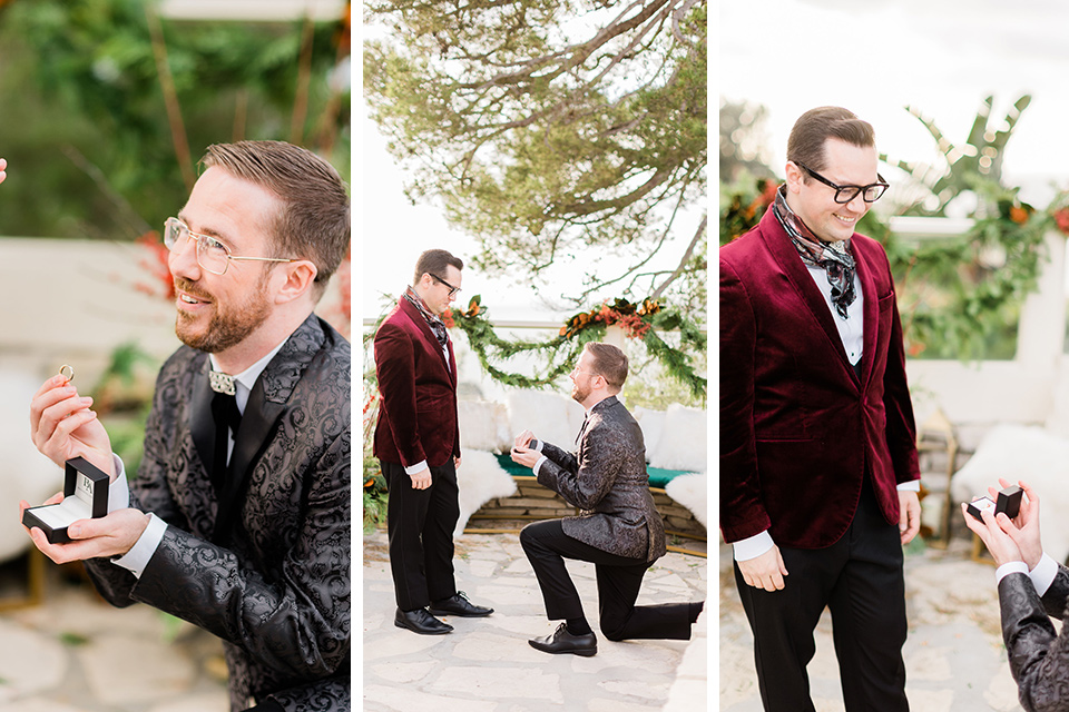  image of a couple getting engaged.  One man is on one knee proposing to his love and the other man is surprised at the engagement, both are smiling and happy