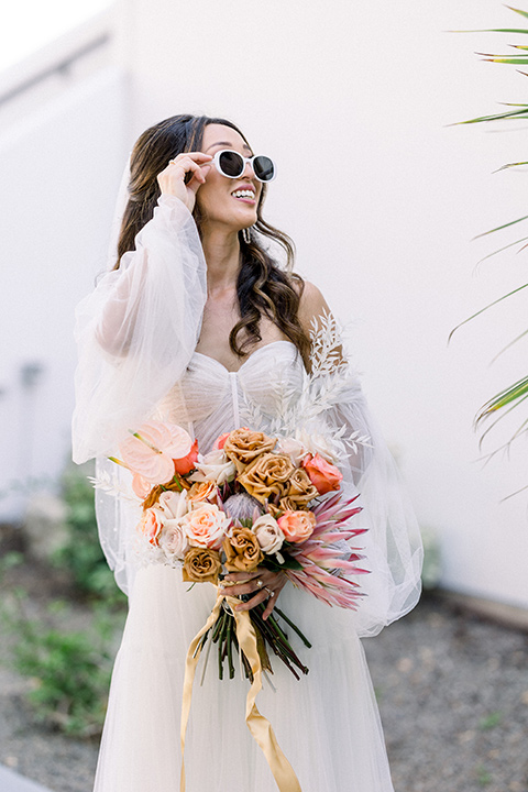  70s inspired wedding with orange and caramel tones with the bride in a lace gown and the groom in a caramel suit - bride 