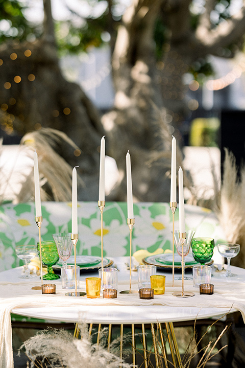  70s inspired wedding with orange and caramel tones with the bride in a lace gown and the groom in a caramel suit - table décor and candles 