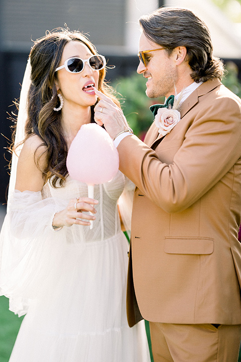  70s inspired wedding with orange and caramel tones with the bride in a lace gown and the groom in a caramel suit - couple smiling outside 