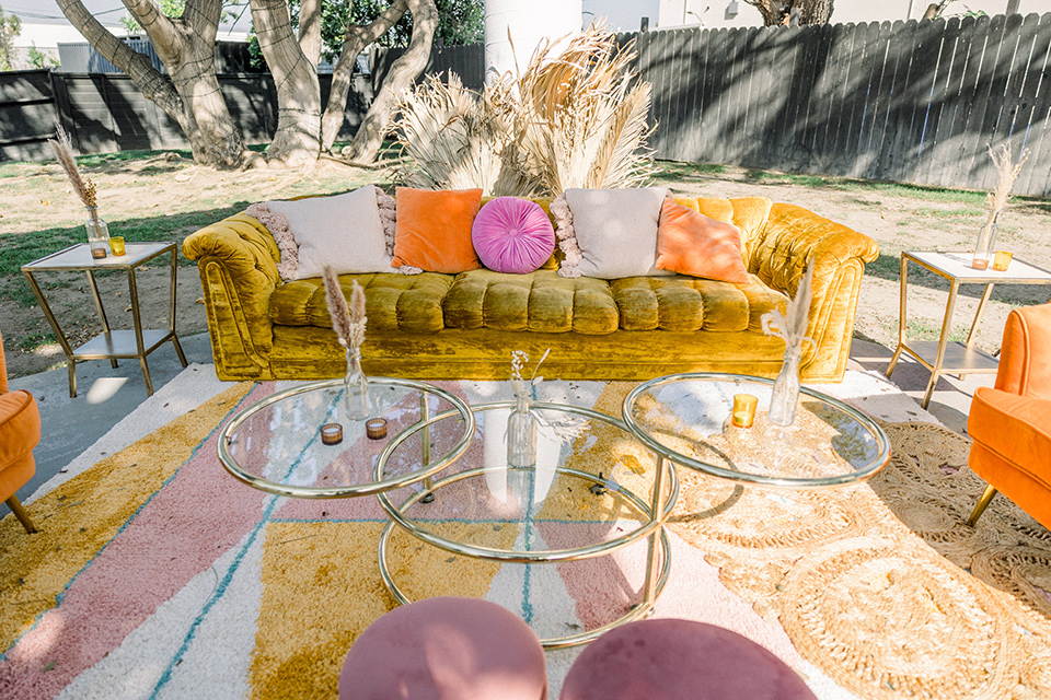  70s inspired wedding with orange and caramel tones with the bride in a lace gown and the groom in a caramel suit - couch and furniture 