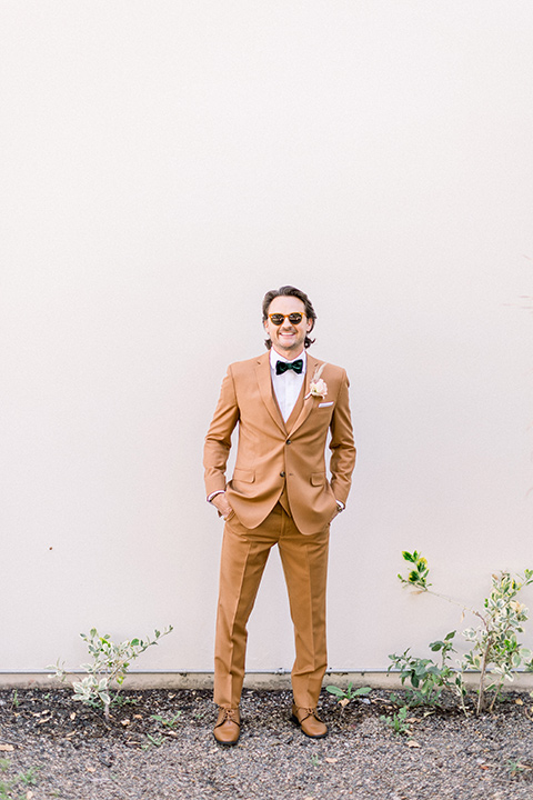  70s inspired wedding with orange and caramel tones with the bride in a lace gown and the groom in a caramel suit - groom 