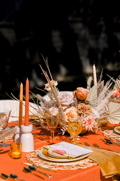  70s inspired wedding with orange and caramel tones with the bride in a lace gown and the groom in a caramel suit - table decor 