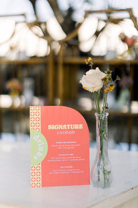  70s inspired wedding with orange and caramel tones with the bride in a lace gown and the groom in a caramel suit - menu and table numbers 