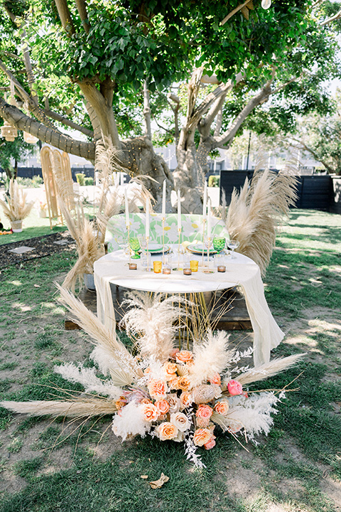  70s inspired wedding with orange and caramel tones with the bride in a lace gown and the groom in a caramel suit - table décor and candles 