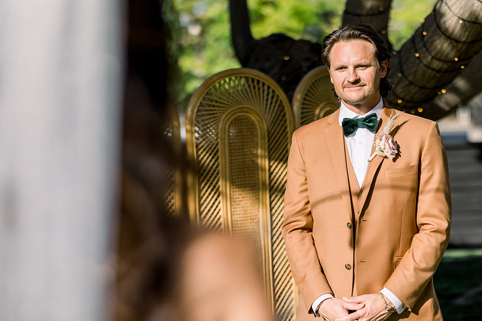  70s inspired wedding with orange and caramel tones with the bride in a lace gown and the groom in a caramel suit - bride walking down the aisle 